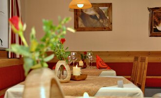 A cozy restaurant with a decorative table view. Flowers and candles are on the tables, creating an inviting atmosphere. | © Michl das Steakhaus | Johannes Littich