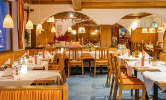 Ein gemütliches Restaurant mit Holzinterieur und liebevoll gedeckten Tischen. Die warmen Farben und die sanfte Beleuchtung schaffen eine einladende Atmosphäre. | © Hotel Alte Krone